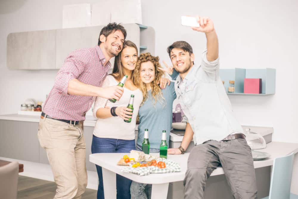 Four friends taking a selfie - Group of people celebrating at home and having fun